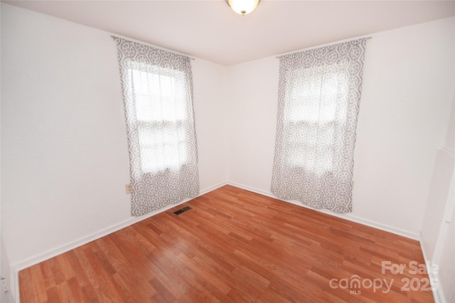 unfurnished room with hardwood / wood-style flooring