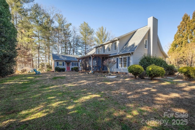 back of property featuring a lawn and a sunroom