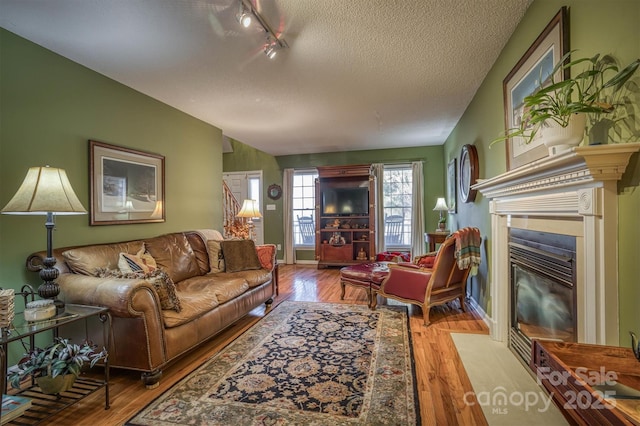 living room with a textured ceiling and light wood-type flooring