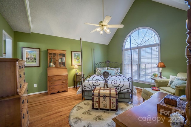 bedroom with high vaulted ceiling, ceiling fan, and light wood-type flooring