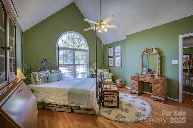 bedroom featuring hardwood / wood-style floors, vaulted ceiling, a textured ceiling, and ceiling fan