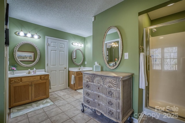 bathroom with vanity, tile patterned flooring, a shower with shower door, and a textured ceiling