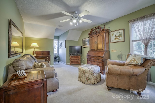 living room with lofted ceiling, plenty of natural light, light colored carpet, and a textured ceiling