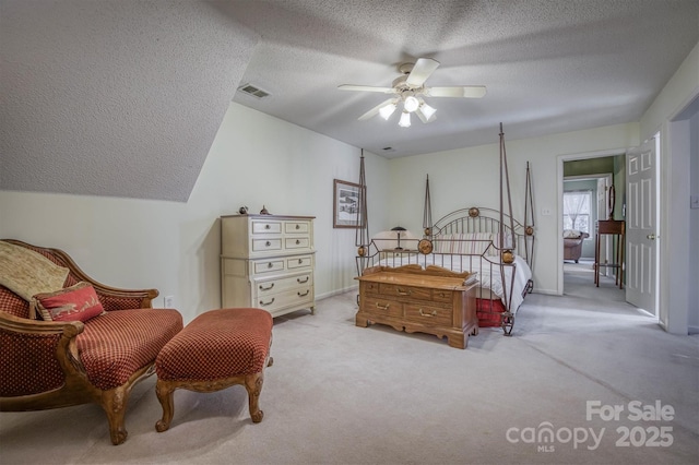 carpeted bedroom with ceiling fan and a textured ceiling