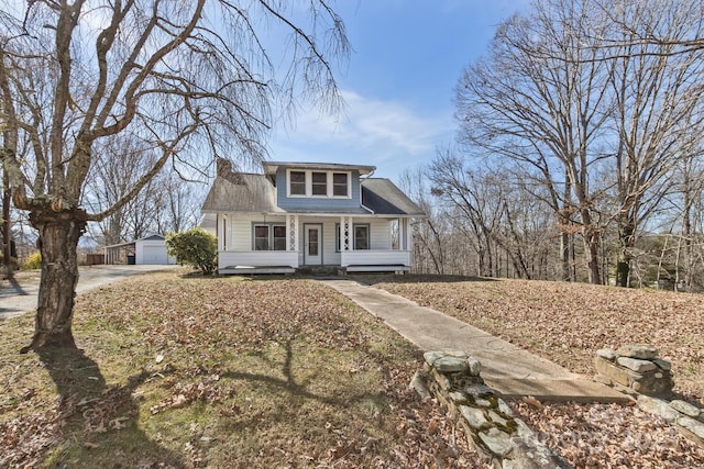 bungalow featuring an outbuilding, a porch, a chimney, and a detached garage