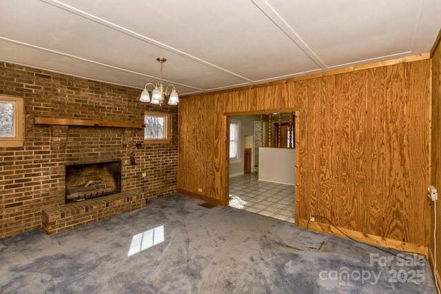 unfurnished living room featuring carpet floors, a fireplace, wooden walls, and brick wall