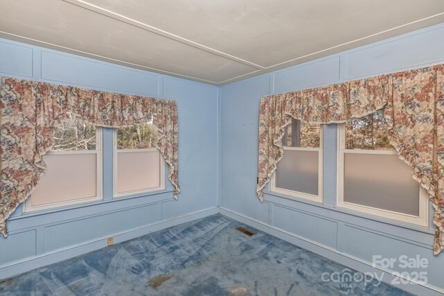 spare room with carpet and a decorative wall