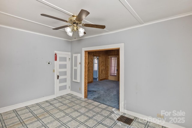 spare room with light colored carpet, crown molding, baseboards, and ceiling fan