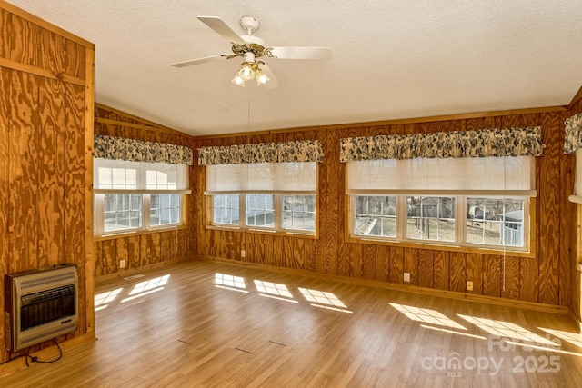 unfurnished sunroom with lofted ceiling, ceiling fan, and heating unit