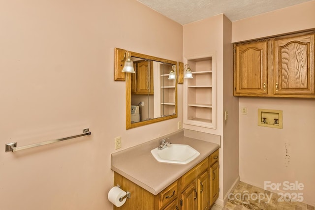 bathroom featuring washer / dryer, vanity, and a textured ceiling