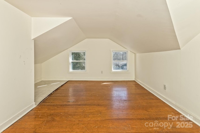bonus room with vaulted ceiling, baseboards, and wood finished floors