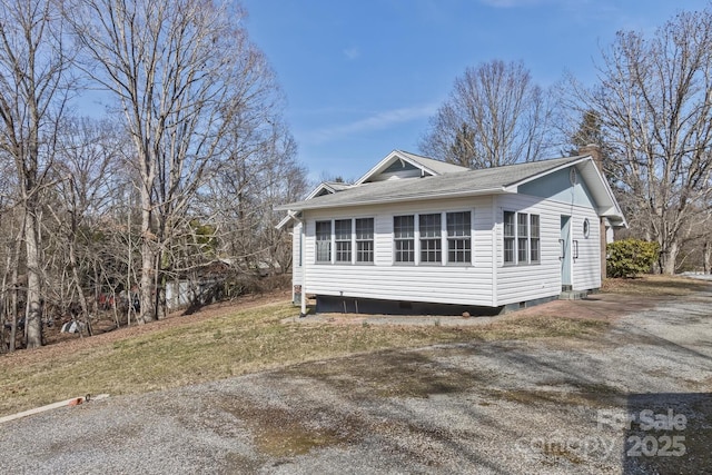 view of side of property featuring crawl space, a yard, and driveway