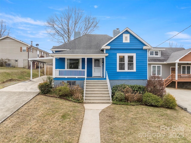 bungalow-style home with central AC, a carport, covered porch, and a front lawn