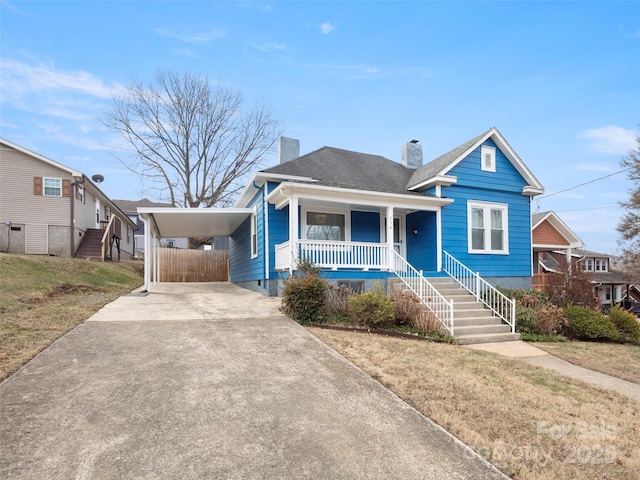 bungalow-style home featuring a carport, a porch, and a front yard