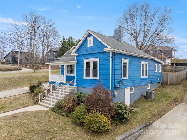 view of property exterior with a yard, central AC, and covered porch