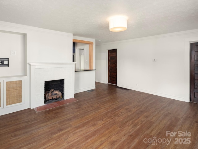 unfurnished living room with ornamental molding, a fireplace, dark hardwood / wood-style flooring, and a textured ceiling