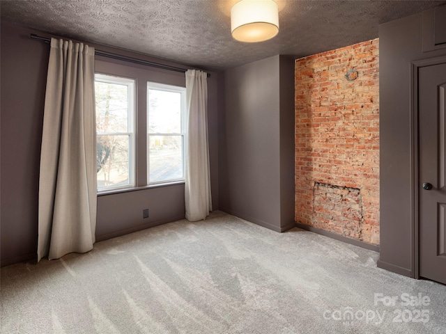 carpeted spare room with a textured ceiling