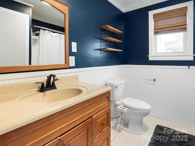 bathroom with vanity, tile patterned floors, ornamental molding, and toilet