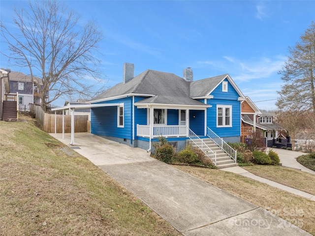 view of front of home featuring a carport, covered porch, and a front yard