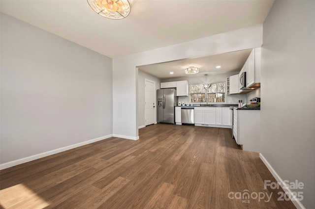 kitchen featuring stainless steel appliances, dark hardwood / wood-style flooring, sink, and white cabinets