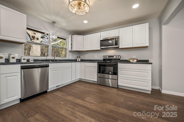 kitchen with white cabinetry, decorative light fixtures, dark hardwood / wood-style flooring, and appliances with stainless steel finishes