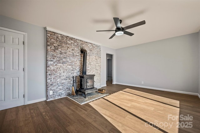 unfurnished living room featuring ceiling fan, dark hardwood / wood-style flooring, and a wood stove