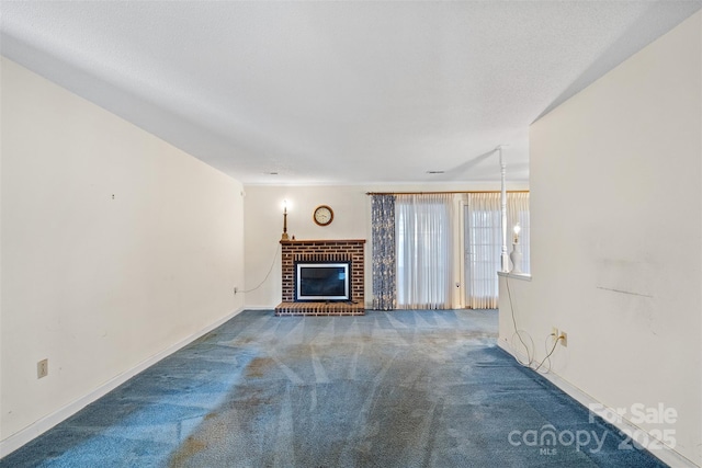 unfurnished living room with a textured ceiling, a fireplace, carpet flooring, and baseboards