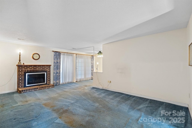 unfurnished living room featuring a textured ceiling, carpet floors, a brick fireplace, and baseboards