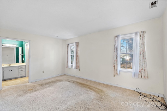 spare room with plenty of natural light, visible vents, baseboards, and light colored carpet