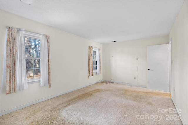 carpeted spare room with baseboards