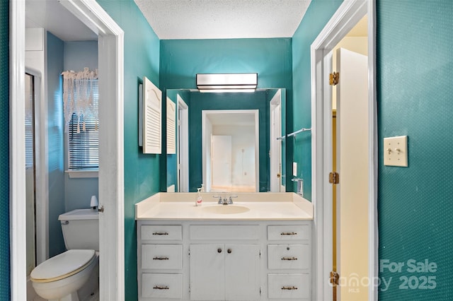 bathroom with toilet, a textured ceiling, and vanity