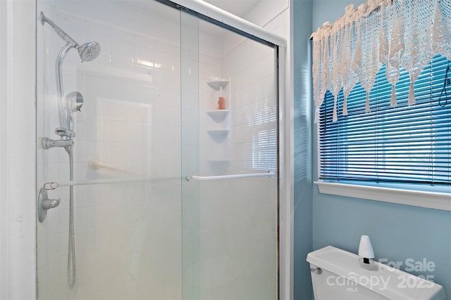 bathroom featuring toilet and a stall shower