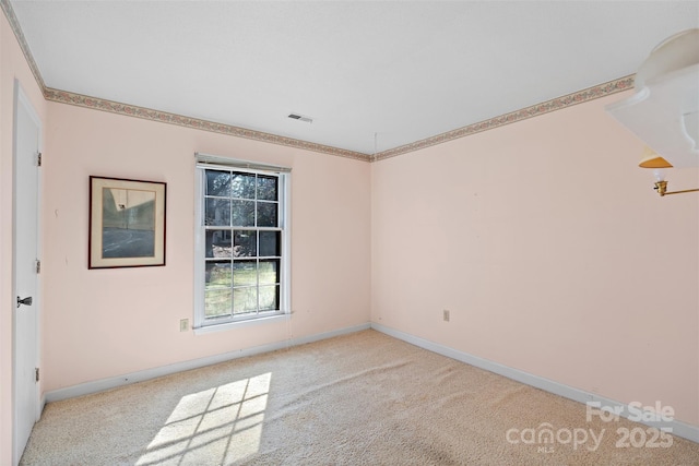 spare room featuring visible vents, light carpet, and baseboards