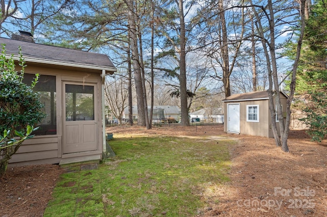 view of yard with an outbuilding, fence, and a storage unit