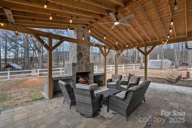 view of patio / terrace with ceiling fan and an outdoor stone fireplace