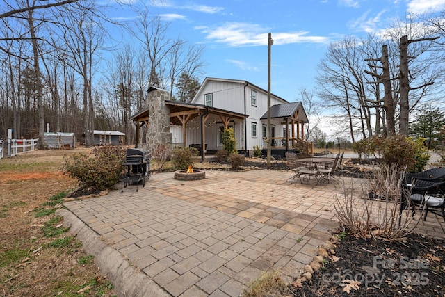 rear view of property with a patio area and a fire pit