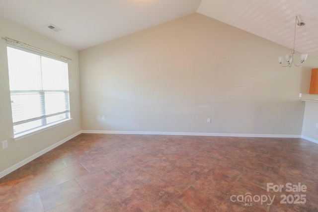 unfurnished room with a notable chandelier, vaulted ceiling, and plenty of natural light