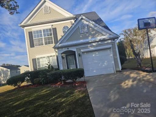 front facade with a garage and a front lawn