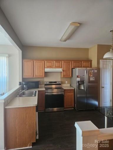 kitchen with sink, decorative light fixtures, dark wood-type flooring, and appliances with stainless steel finishes