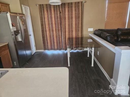 interior space featuring dark wood-type flooring and stainless steel fridge