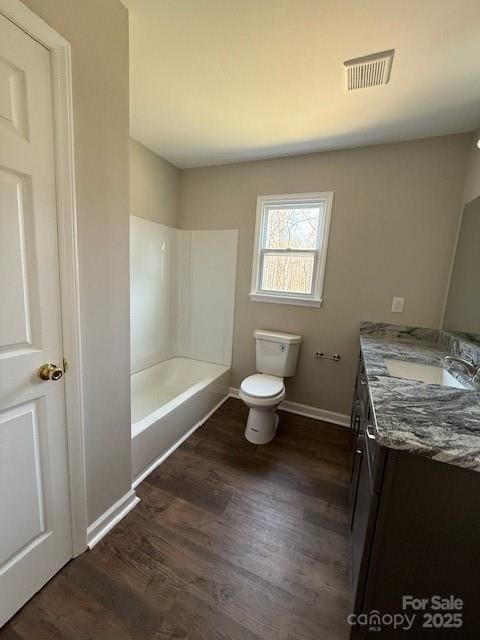 full bathroom featuring vanity, hardwood / wood-style floors,  shower combination, and toilet