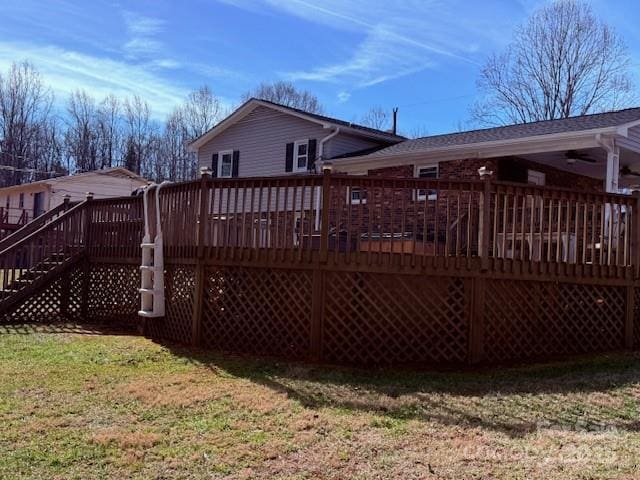 back of house with a wooden deck and a lawn