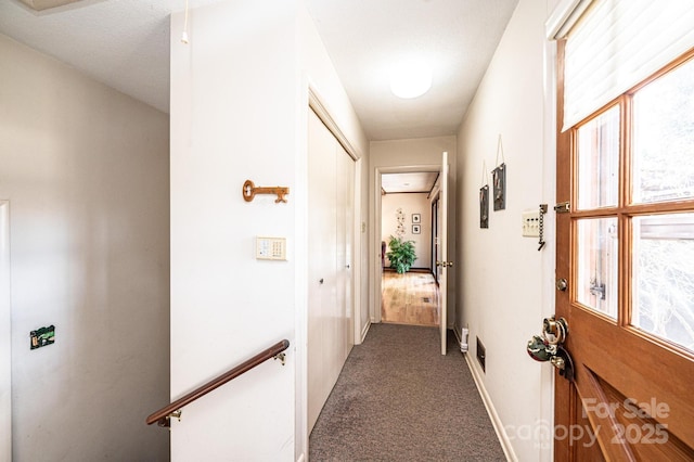 hall with dark colored carpet