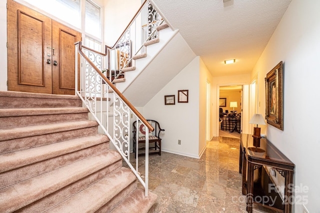 stairs featuring a textured ceiling