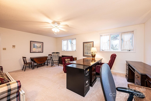 office space featuring light carpet, a textured ceiling, and ceiling fan