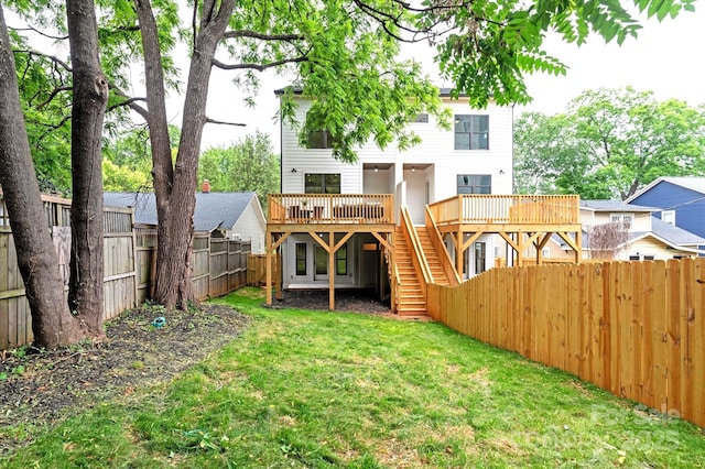 back of house with a wooden deck and a yard