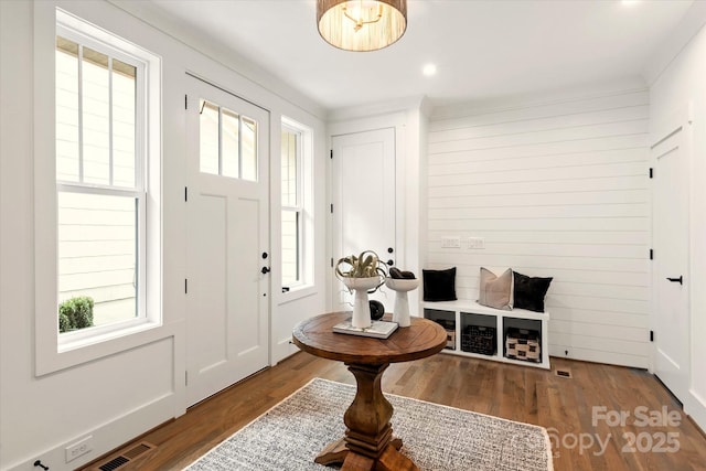 foyer entrance featuring hardwood / wood-style flooring and wooden walls