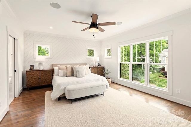 bedroom with ornamental molding, dark hardwood / wood-style flooring, wooden walls, and ceiling fan