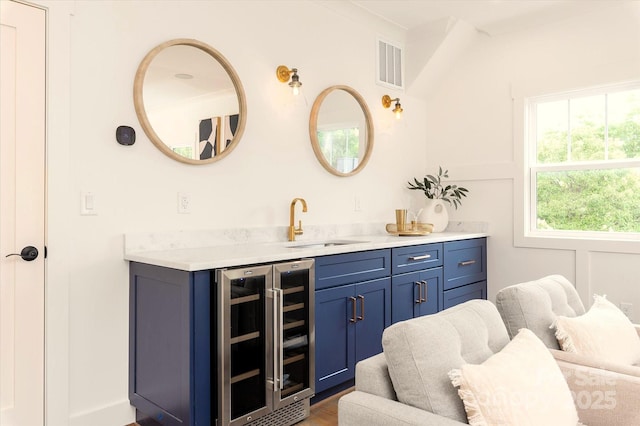 bathroom with wine cooler, vanity, and ornamental molding