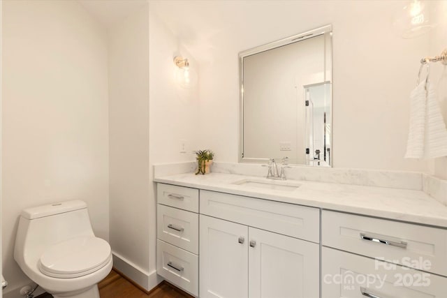 bathroom featuring vanity, hardwood / wood-style floors, and toilet